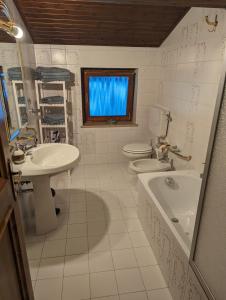 a bathroom with two toilets and a sink and a tub at Appartement Il Gallo in Forno di Zoldo