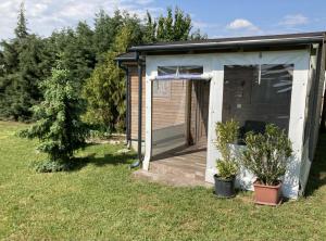 a small shed with a deck and plants in the grass at NEUTRINO VENDÉGHÁZ in Zánka