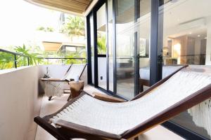 a room with a balcony with chairs and windows at Casa Imox Luxe Studio in Tulum