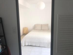sypialnia z łóżkiem w białym pokoju w obiekcie * Maison de Ville en Pleine Nature * w Marsylii