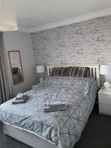 a bedroom with a bed with a patterned wall at Villa sea view 3-bed heated pool eat bar kids park in Lowestoft