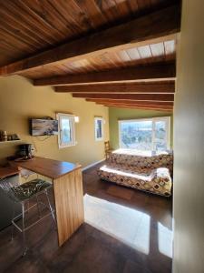 a bedroom with a bed and a table and a window at Maiten Apartamentos in San Carlos de Bariloche
