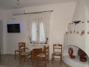 a dining room with chairs and a table and a window at ilioni house in Skopelos Town