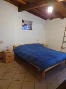 ein großes blaues Bett in einem Zimmer mit einer Leiter in der Unterkunft Casa intera indipendente con giardino privato in Imperia