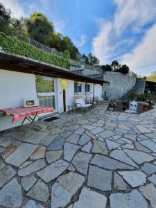 eine Steinterrasse mit einem Haus und einem Gebäude in der Unterkunft Casa intera indipendente con giardino privato in Imperia