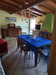 Casa intera indipendente con giardino privato في إمبيريا: غرفة طعام مع طاولة وكراسي زرقاء