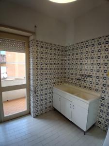 La salle de bains est pourvue d'un lavabo blanc et d'une fenêtre. dans l'établissement Casa dei miei, à Sperlonga