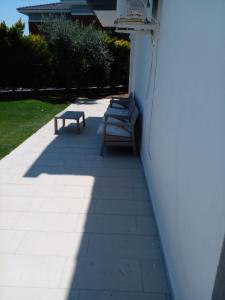 two benches sitting on the side of a building at Luxury villa 3 bedrooms swimming pool in Cesme