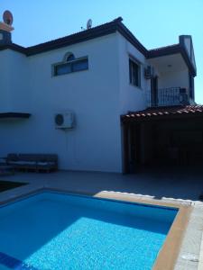 a swimming pool in front of a house at Luxury villa 3 bedrooms swimming pool in Cesme