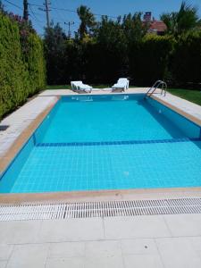 a swimming pool with blue tiles in a yard at Luxury villa 3 bedrooms swimming pool in Cesme