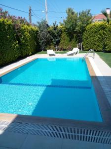 a swimming pool with blue water in a yard at Luxury villa 3 bedrooms swimming pool in Cesme