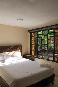 a bedroom with a large bed and a large window at Casa Lilí Guaduas in Guaduas