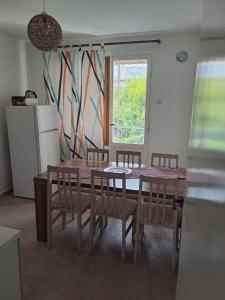a kitchen with a table and chairs and a window at apartman ANAMI in Bar