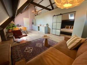 uma sala de estar com um sofá e um quarto em LooSan Lodges em Reutum