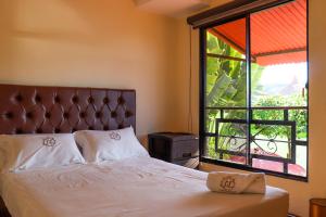 um quarto com uma cama e uma grande janela em Casa Lilí Guaduas em Guaduas