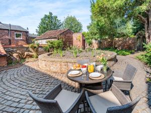 a patio with a table and chairs in a backyard at Priests Abode - Uk40759 in Barrow upon Humber