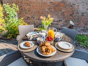 a table with a breakfast of croissants and fruit at Priests Abode - Uk40759 in Barrow upon Humber