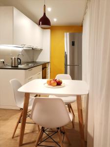 Una mesa blanca en una cocina con un plato de fruta. en Green leaf apartments en Liepāja