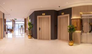 um lobby com duas portas e plantas na parede em مستقر للشقق الفندقية الياسمين em Hail