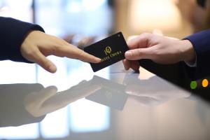 une personne remettant une carte de crédit à une autre personne dans l'établissement Hotel Opera, à Pristina
