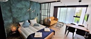 a bedroom with a large bed and a living room at Lake View Mielno in Mielno