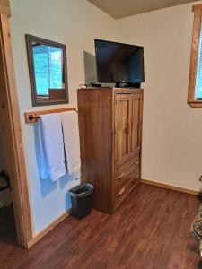 ein Wohnzimmer mit einem TV und einem Schrank mit Handtüchern in der Unterkunft Southern Bluff Bed & Breakfast in Soldotna
