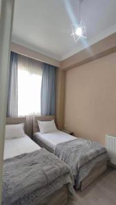 - une chambre avec 2 lits et une fenêtre dans l'établissement Guest House NIMA, à Koutaïssi