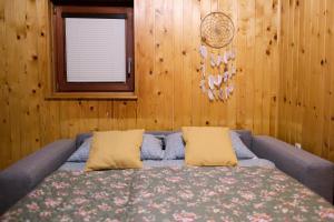 a bedroom with a bed with two pillows and a window at Wooden house Ažbe in Bled