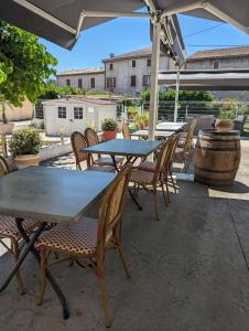 einen Tisch und Stühle unter einem Sonnenschirm auf einer Terrasse in der Unterkunft Hôtel Restaurant Le Clos Charmant in Vallon-Pont-dʼArc