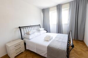 a bedroom with a bed with white sheets and a window at Apartment Srecko in Omiš +36 photos