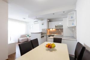 a kitchen and a table with a bowl of fruit on it at Apartment Srecko in Omiš