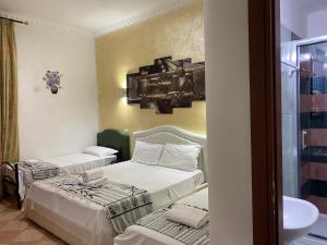 um quarto com duas camas e um lavatório em Aquarium Termini em Roma