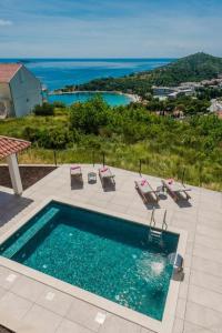 uma piscina com cadeiras e vista para o oceano em Villa Vista em Mlini