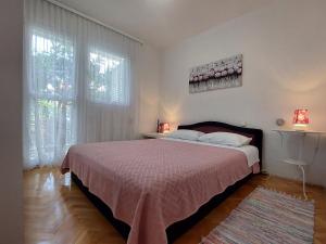 una camera con letto e copriletto rosa di Apartment Emili Marina a Marina