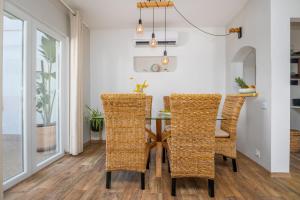 a dining room with a table and wicker chairs at Villa Oasis with private pool in Milna