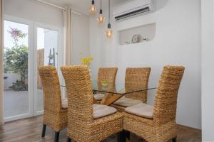 een eetkamer met een glazen tafel en rieten stoelen bij Villa Oasis with private pool in Milna