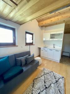 Il comprend un salon avec un canapé bleu et une cuisine. dans l'établissement Kuschelige Wohnung im Eisacktal, à Villandro