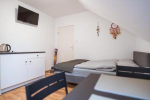 a bedroom with a bed and a tv on a wall at Dom Gościnny Latarenka in Niechorze