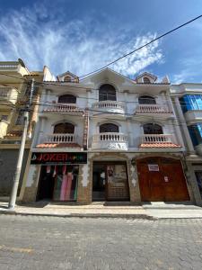 a large white building on the corner of a street at Hostal Arauco in Otavalo