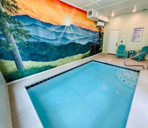 a swimming pool in a room with a mountain mural on the wall at Blackberry Chalet in Sevierville