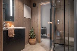 a bathroom with a sink and a shower with a christmas tree at Exclusive Cabin Apartment with Sauna - 601 in Stranda