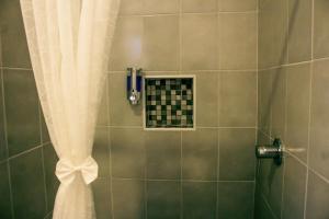 a shower with a white shower curtain and a window at La Quinta Caribeña in Playa del Carmen