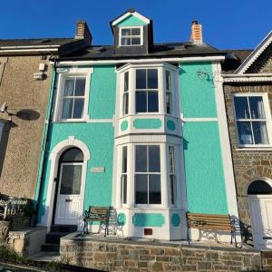 a blue house with a bench in front of it at Swn Y Don New Quay in New Quay