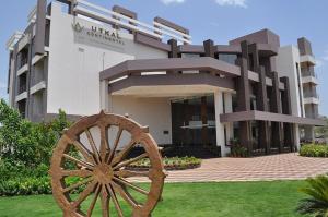a building with a wooden wheel in front of it at Pipul Utkal Continental in Jhārsuguda