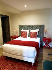 Résidence Cœur de Village في جوسيير: غرفة نوم مع سرير أبيض كبير مع وسائد حمراء