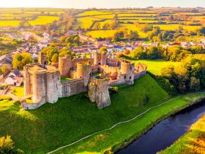 an aerial view of a castle with a river at The Big Cwtch Shepherd's Hut in Kidwelly