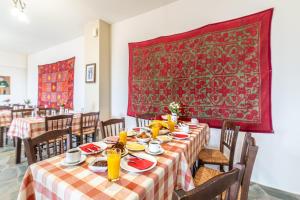 a dining room with a table with a red rug at Hotel Marina in Anogia