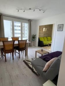- un salon avec un canapé, une table et des chaises dans l'établissement Appartement à 150m du lac- plage de l’Impérial, à Annecy