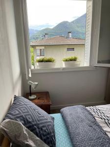- une chambre avec une fenêtre donnant sur une maison dans l'établissement Appartement à 150m du lac- plage de l’Impérial, à Annecy