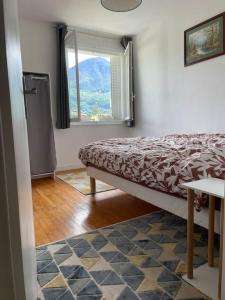 - une chambre avec un lit, une fenêtre et une table dans l'établissement Appartement à 150m du lac- plage de l’Impérial, à Annecy